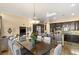 Open-concept kitchen and dining area featuring dark cabinetry, stainless steel appliances, and a large island at 12 Wade Hampton Trl, Henderson, NV 89052