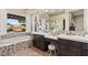 Stylish main bathroom featuring dual sinks, a soaking tub with a view, and decorative tile accents at 12 Wade Hampton Trl, Henderson, NV 89052