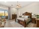 Luxurious main bedroom with wood floors, decorative rug, carved wood furniture and doors to the patio at 12 Wade Hampton Trl, Henderson, NV 89052