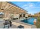 Luxurious backyard with a shimmering pool, covered patio, and outdoor seating, ideal for relaxation and entertaining at 12 Wade Hampton Trl, Henderson, NV 89052