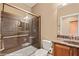 Bathroom featuring glass enclosed shower, toilet, and vanity with dark wood cabinetry at 1455 Waterfall Ln, Mesquite, NV 89034