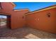 Paver-covered courtyard, with rust colored walls, outdoor lighting and a gate to a community space at 1455 Waterfall Ln, Mesquite, NV 89034