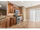 Modern kitchen with stainless steel appliances, wood cabinets, and tile flooring at 1455 Waterfall Ln, Mesquite, NV 89034