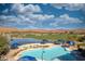 Overhead view of a swimming pool and golf course set against a mountain vista at 1455 Waterfall Ln, Mesquite, NV 89034