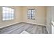 Empty bedroom featuring gray wood-look flooring, neutral paint, and two large grid windows at 2131 Hussium Hills St # 104, Las Vegas, NV 89108