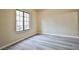 Bedroom with gray wood-look flooring, neutral walls, and a large grid window allowing natural light at 2131 Hussium Hills St # 104, Las Vegas, NV 89108