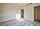 Bright bedroom with gray wood-look flooring and two doorways, one leading to the bathroom with laundry at 2131 Hussium Hills St # 104, Las Vegas, NV 89108