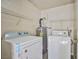 A compact laundry room that has a side-by-side washer and dryer, and plenty of shelf space at 2131 Hussium Hills St # 104, Las Vegas, NV 89108