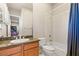 Well-lit bathroom with a granite countertop vanity, a tub with shower, and a large mirror at 2285 Villefort Ct, Las Vegas, NV 89117