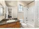 Bright bathroom features a granite-topped vanity and shower-tub combination with glass door at 2285 Villefort Ct, Las Vegas, NV 89117