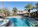 A beautiful pool with a stone waterfall feature and palm trees in the backyard at 2285 Villefort Ct, Las Vegas, NV 89117