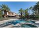 A backyard pool surrounded by lush greenery and palm trees at 2285 Villefort Ct, Las Vegas, NV 89117