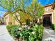 Welcoming front entrance with iron gate, blooming roses, and manicured shrubs at 2357 Wisconsin Dells Dr, Henderson, NV 89044