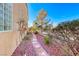 Side yard featuring stone pathway, desert landscaping, and wrought iron fence in the background at 2357 Wisconsin Dells Dr, Henderson, NV 89044