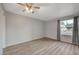 Empty bedroom with wood-look vinyl flooring, large window, ceiling fan, and neutral gray paint at 2451 N Rainbow Blvd # 1150, Las Vegas, NV 89108