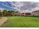 Well-maintained apartment buildings surround a lush green lawn under a partly cloudy sky at 2451 N Rainbow Blvd # 1150, Las Vegas, NV 89108