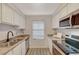 A clean kitchen showcasing a double sink, stainless steel appliances, granite countertops, and wood-look vinyl flooring at 2451 N Rainbow Blvd # 1150, Las Vegas, NV 89108