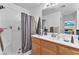 Bathroom with a shower-tub combo, wooden vanity, and a large mirror at 2526 Begonia Valley Ave, Henderson, NV 89074