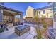 Outdoor patio featuring a fire pit, covered seating area, and landscaped surroundings at 2641 Via Monet, Henderson, NV 89044