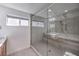 Modern bathroom features a glass shower, tiled walls, and a bright window at 2641 Via Monet, Henderson, NV 89044