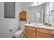 Well-lit bathroom with a wood vanity, modern fixtures, and a wall cabinet at 2641 Via Monet, Henderson, NV 89044