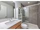 Bathroom with a wood vanity, white sink and tile shower with glass door at 2641 Via Monet, Henderson, NV 89044