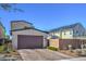 Contemporary home with a brown garage door, solar panels on the roof of the adjacent property, and desert landscaping at 2641 Via Monet, Henderson, NV 89044