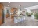 Bright kitchen featuring a large island with seating, stainless steel appliances, and tile flooring at 2641 Via Monet, Henderson, NV 89044