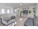 Bright living room with neutral colored walls and a gray futon next to two chairs at 2641 Via Monet, Henderson, NV 89044