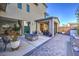 Gorgeous backyard patio with a blue glass firepit, elegant tile work, and sliding doors leading to the dining area at 2641 Via Monet, Henderson, NV 89044