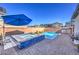 Beautiful backyard featuring a pool and spa with a blue umbrella for shade, perfect for relaxation and recreation at 2641 Via Monet, Henderson, NV 89044