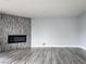 Spacious living room featuring an electric fireplace with tile accent wall and gray wood floors at 2720 Beaver Creek Ct # 202, Las Vegas, NV 89117