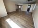 Bright living room with wood laminate flooring and an open layout flowing into the dining and kitchen areas at 3118 Honeysuckle Ave, North Las Vegas, NV 89031