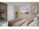 Bright bedroom featuring a closet, neutral walls, large window with beautiful sunset views, and modern artwork at 350 Robledo St, Las Vegas, NV 89138