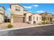 Two-story home with a brick driveway, a two-car garage, stone veneer, and desert landscaping at 350 Robledo St, Las Vegas, NV 89138