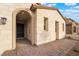 Charming front porch with a brick walkway, stone veneer, an arched entryway, and dark wooden front door at 350 Robledo St, Las Vegas, NV 89138