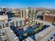 Aerial view of the condo building featuring a pool, palm trees, and city views with mountains at 353 E Bonneville Ave # 1407, Las Vegas, NV 89101