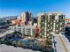 Aerial view of condominium buildings with community pool, palm trees and city view with mountain backdrop at 353 E Bonneville Ave # 1407, Las Vegas, NV 89101