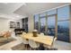 Contemporary dining area with a wooden table, modern chairs, and floor-to-ceiling windows with city views at 353 E Bonneville Ave # 1407, Las Vegas, NV 89101