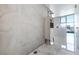 Minimalist living room featuring modern wine storage and an exposed concrete accent wall with white marble floors at 353 E Bonneville Ave # 1407, Las Vegas, NV 89101