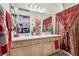 Bathroom featuring double sinks, wood cabinets, and a decorative shower curtain at 3805 Sorrowing Sparrow Ct, North Las Vegas, NV 89032