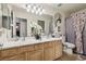 Bathroom featuring double sinks, wood cabinets, and a decorative shower curtain at 3805 Sorrowing Sparrow Ct, North Las Vegas, NV 89032