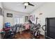 Bedroom with laminate floors, ceiling fan, two desks, two chairs, and exercise equipment at 3805 Sorrowing Sparrow Ct, North Las Vegas, NV 89032