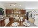 Kitchen with stainless appliances, dark wood cabinets, tile backsplash, and adjacent dining area at 3805 Sorrowing Sparrow Ct, North Las Vegas, NV 89032