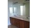 Bathroom featuring a double sink vanity with a large mirror and modern lighting at 4039 Meadow Foxtail Dr, Las Vegas, NV 89122