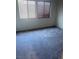 Bright bedroom featuring neutral carpet, two windows, and classic blinds at 4039 Meadow Foxtail Dr, Las Vegas, NV 89122