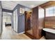 Bathroom featuring a walk-in shower, soaking tub, and wood-look wall design at 5049 Forest Oaks Dr, Las Vegas, NV 89149