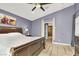 Bedroom with wood floors, a large bed, a ceiling fan, and a calming, neutral-colored palette at 5049 Forest Oaks Dr, Las Vegas, NV 89149