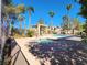 Community pool area, featuring a spa and shaded pergola, surrounded by lush landscaping and palm trees at 5049 Forest Oaks Dr, Las Vegas, NV 89149