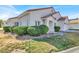 Charming single-story home with a well-manicured front yard, a terracotta tile roof, and an attached two-car garage at 5049 Forest Oaks Dr, Las Vegas, NV 89149